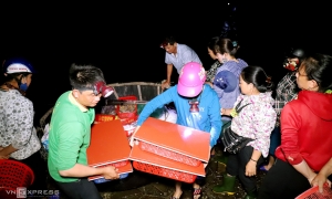 Headlamps shine on a 600-year-old seafood market in central Vietnam