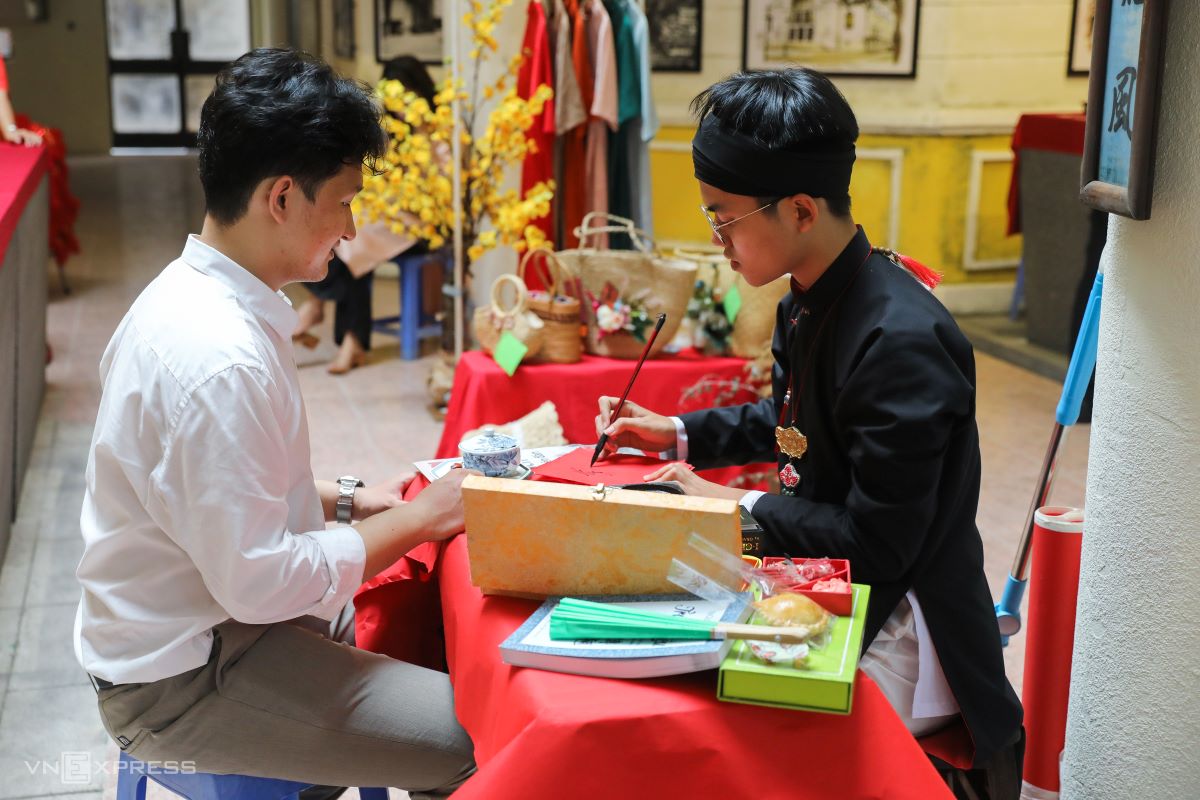 A calligrapher (in black dress) writes beautiful characters which are expected to herald good lucks for the New Year. The event also featured a reenactment of fortune telling that used to be popular during Tet by reading straws or quoting the renowned poem ‘The Tale of Kieu’ by the great poet Nguyen Du of the 19th century.