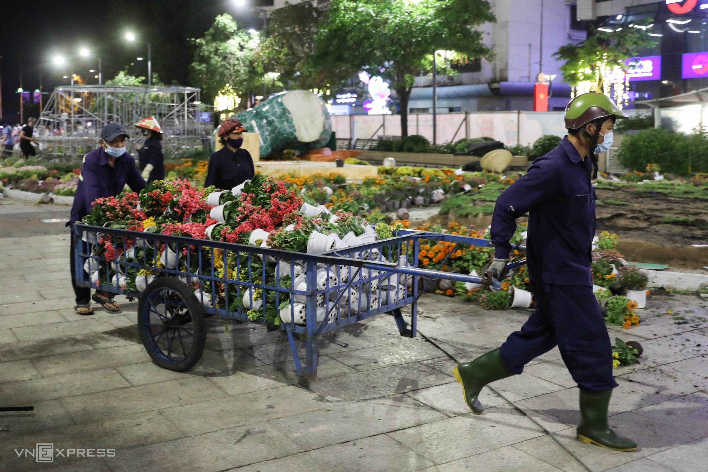This year a fence was built close to the sidewalk of Nguyen Hue pedestrian street to prevent people from flooding the area to grab flowers during the clear out, said a supervisor.