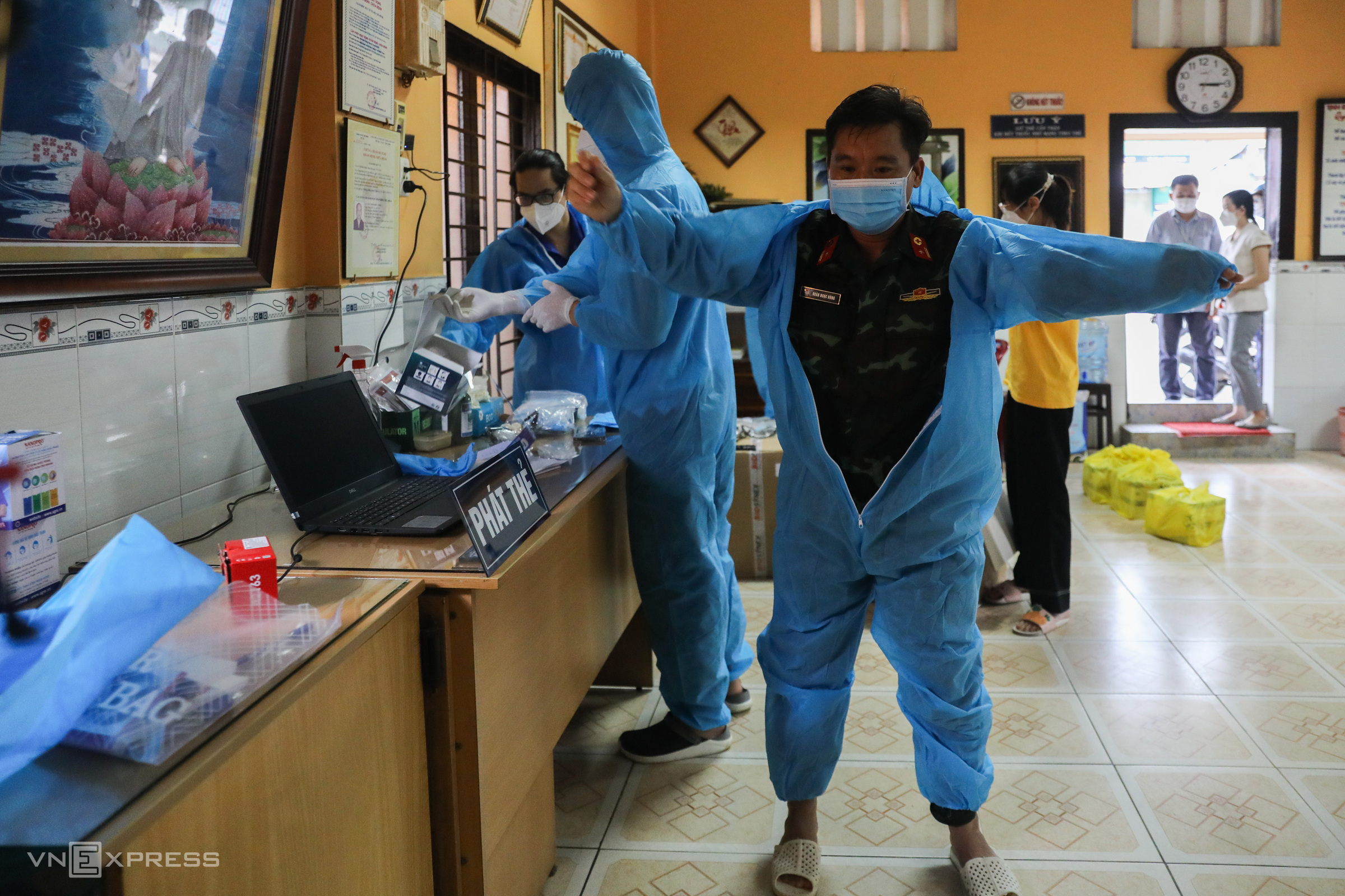 At a mobile medical station in Ward 11 of Binh Thanh District, Doan Ngoc Hung, a doctor from the Vietnam Military Medical University, wears a protective suit on his first day at work in Ho Chi Minh City on Monday.Each mobile medical station has around 4-6 members in charge of management, treating Covid-19 cases at home and vaccinating, among other tasks.